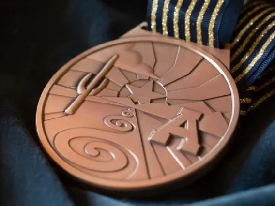 gold medallion featuring saguaro and block &quot;A&quot;
